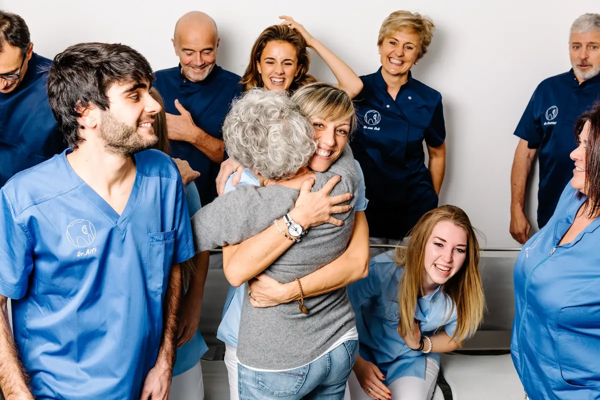 Il team dello Studio Dentistico Sassi-Cok abbraccia una paziente nello studio di Uggiate Trevano